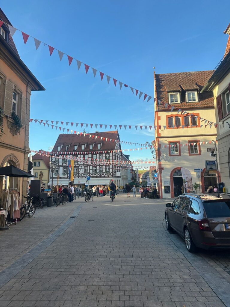 Gasse in Volkach mit bunten Wimpeln im Abendlicht