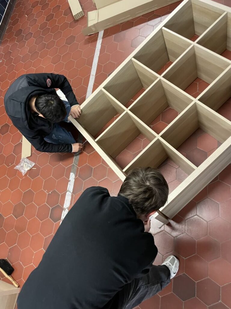 Zwei Schüler montieren von oben gesehen ein Regal